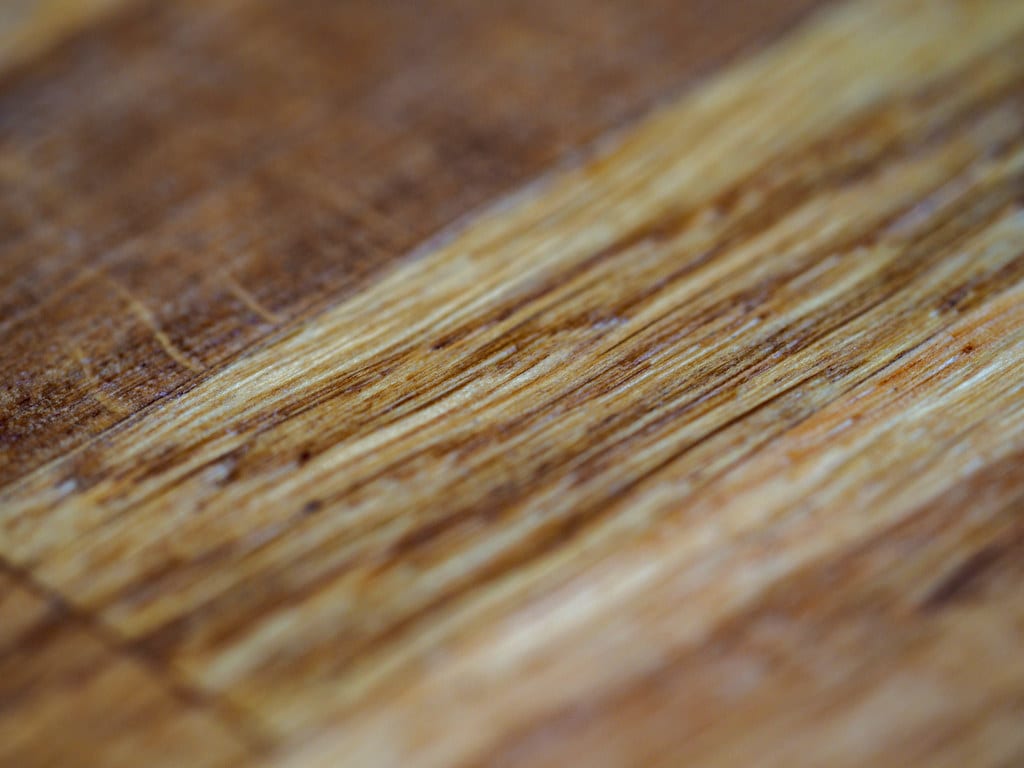 Warm wood grain brought out by a finish, the surface of a small turned piece