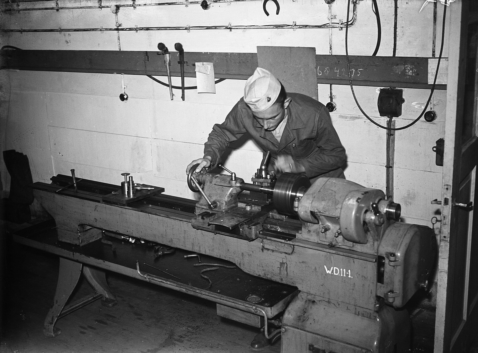 A turner working between centers at a floor lathe