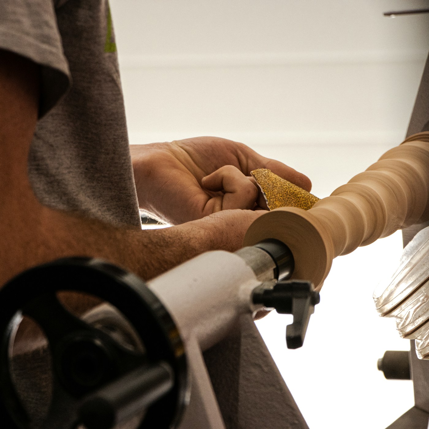 A woodturning workshop with tools organized on the wall and a floor lathe positioned in the center