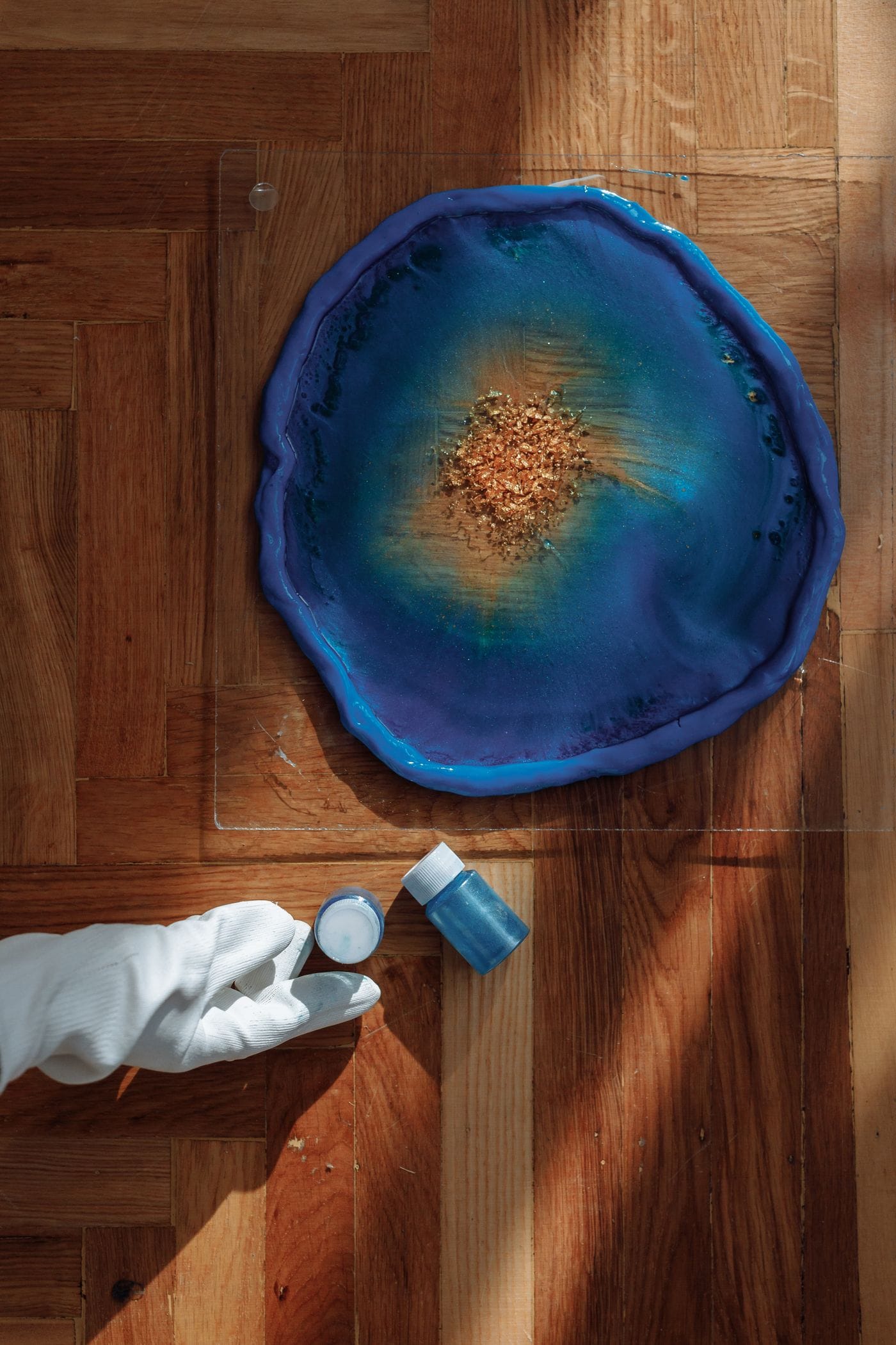 Colorful resin being poured and cured in small craft molds