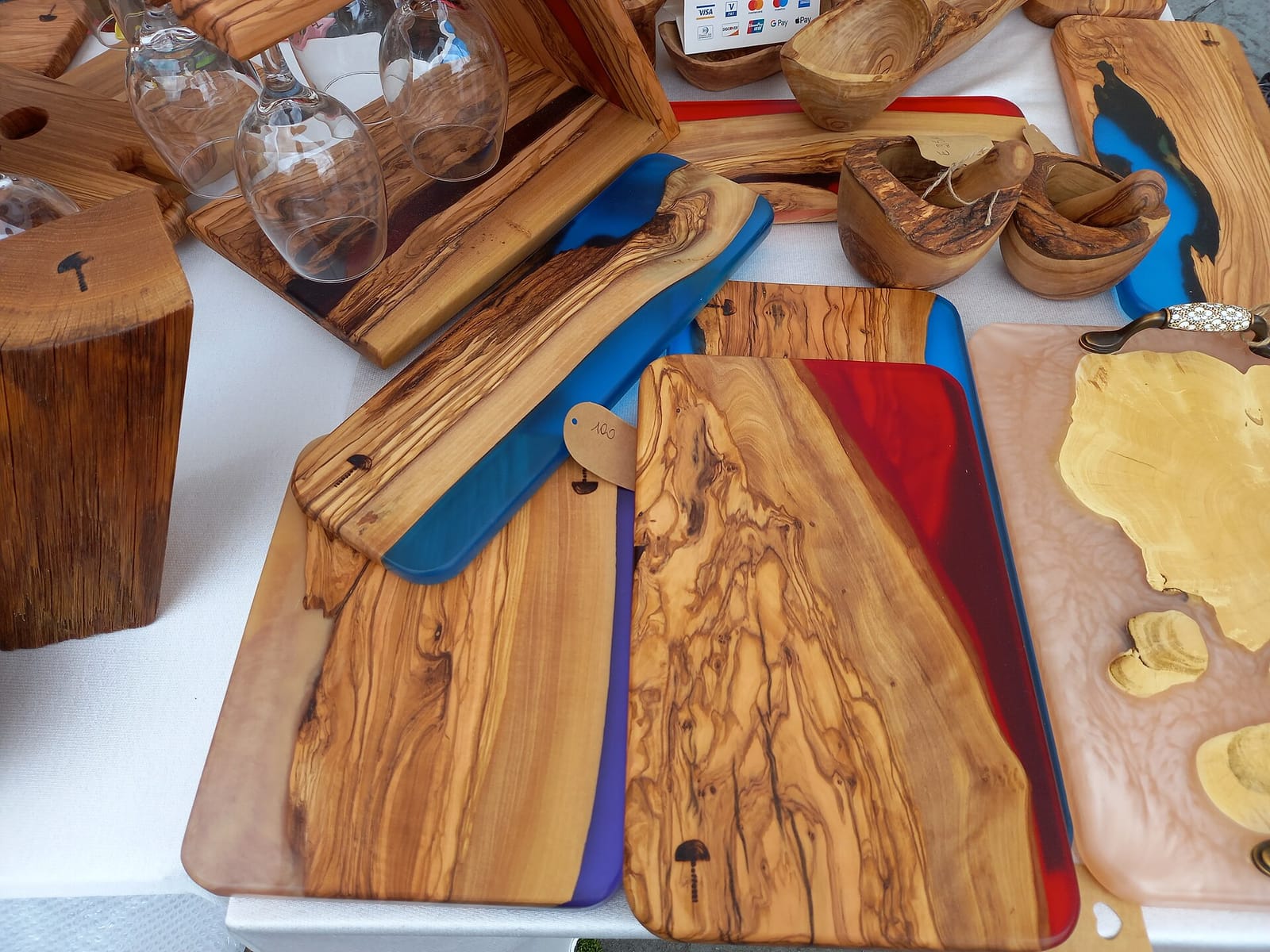 Turned wooden plates with epoxy resin filling the natural voids and grain lines of the wood, displayed at an outdoor market