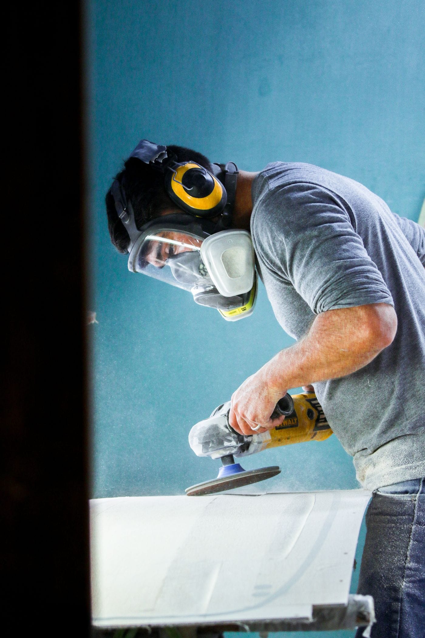 A woodworker wearing a protective face mask while operating a power tool in a workshop