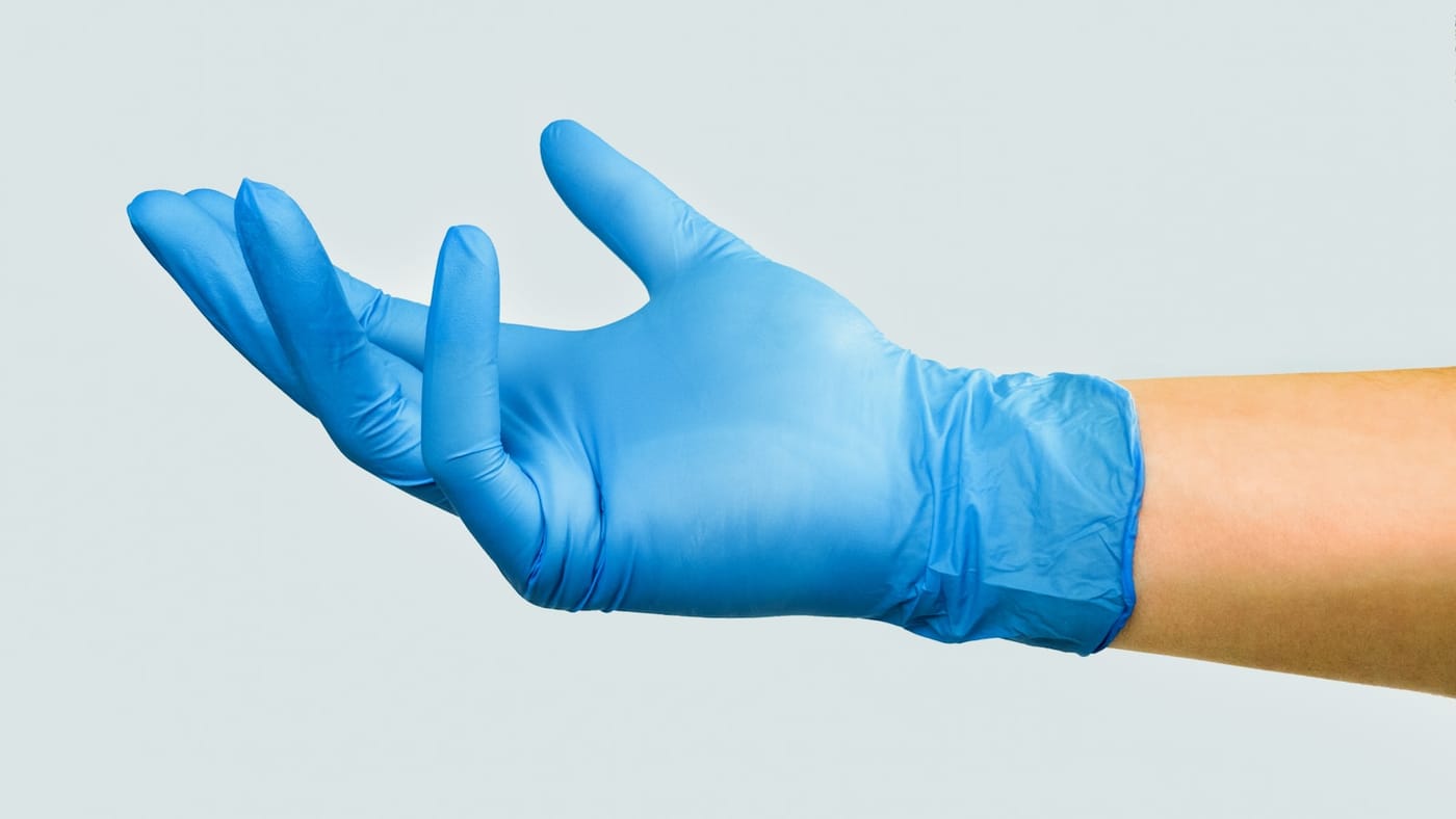 A pair of blue nitrile gloves, the standard hand protection for handling stabilizing resin