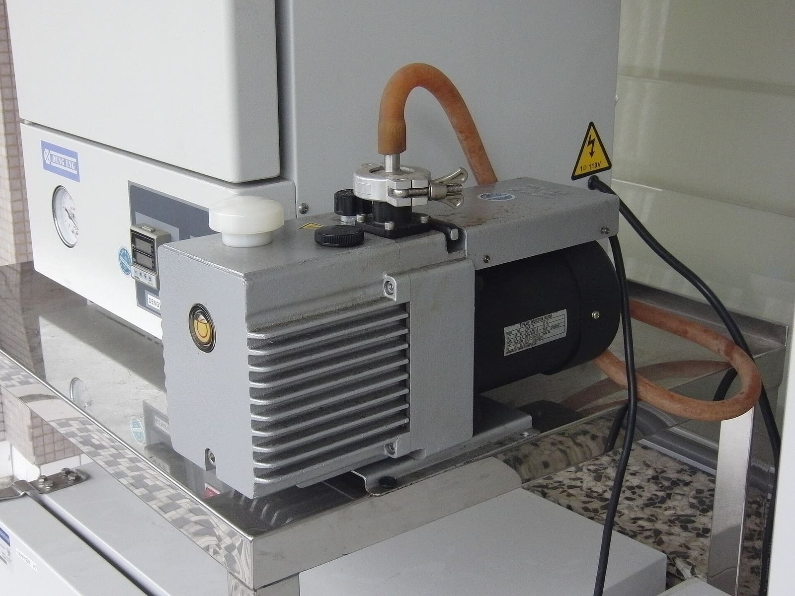An oil-sealed rotary vane vacuum pump, the type used to pull vacuum on a wood-stabilizing chamber