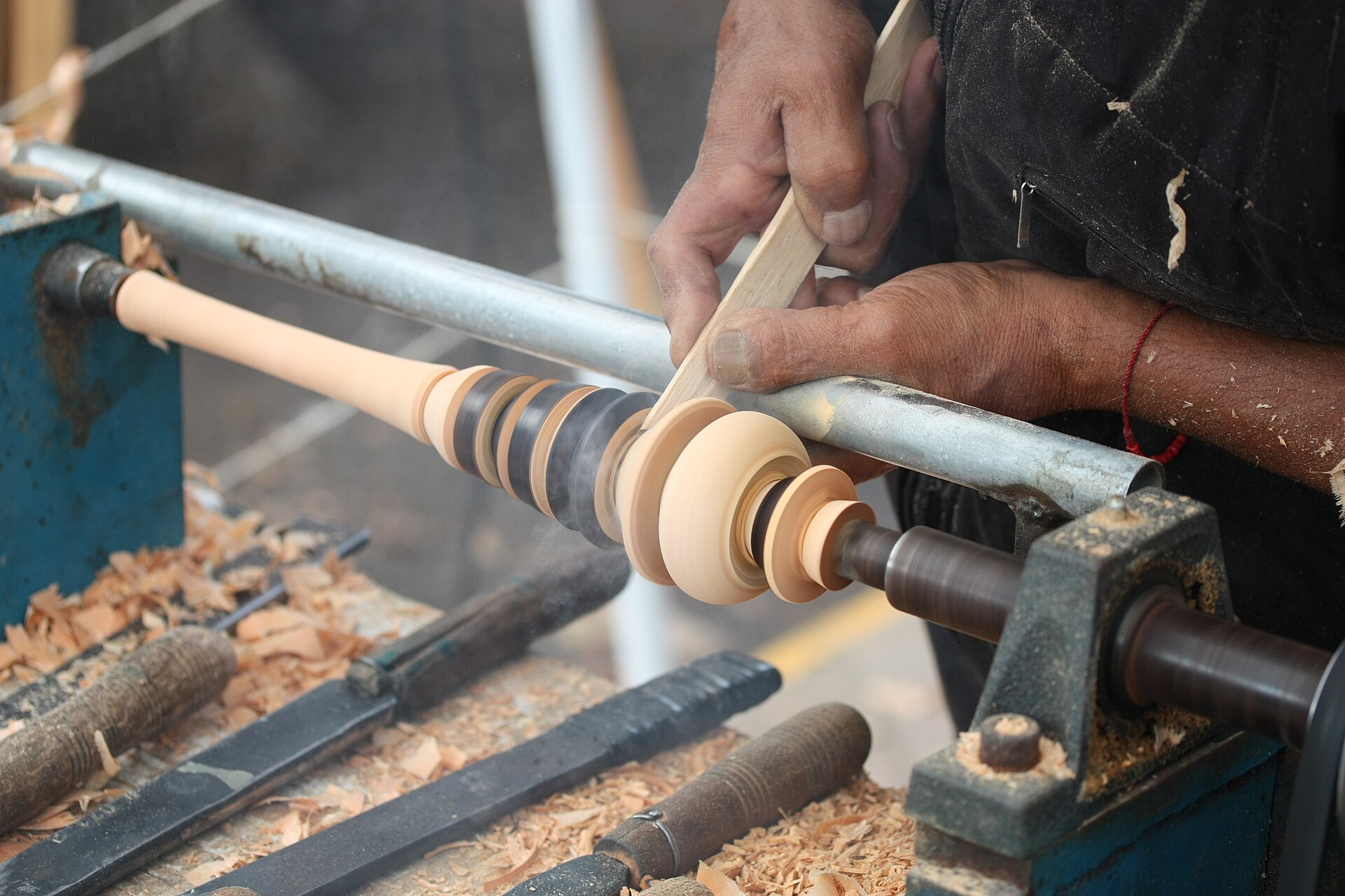 Traditional woodturning process: shaping a molinillo (Mexican wooden kitchen utensil) on a lathe